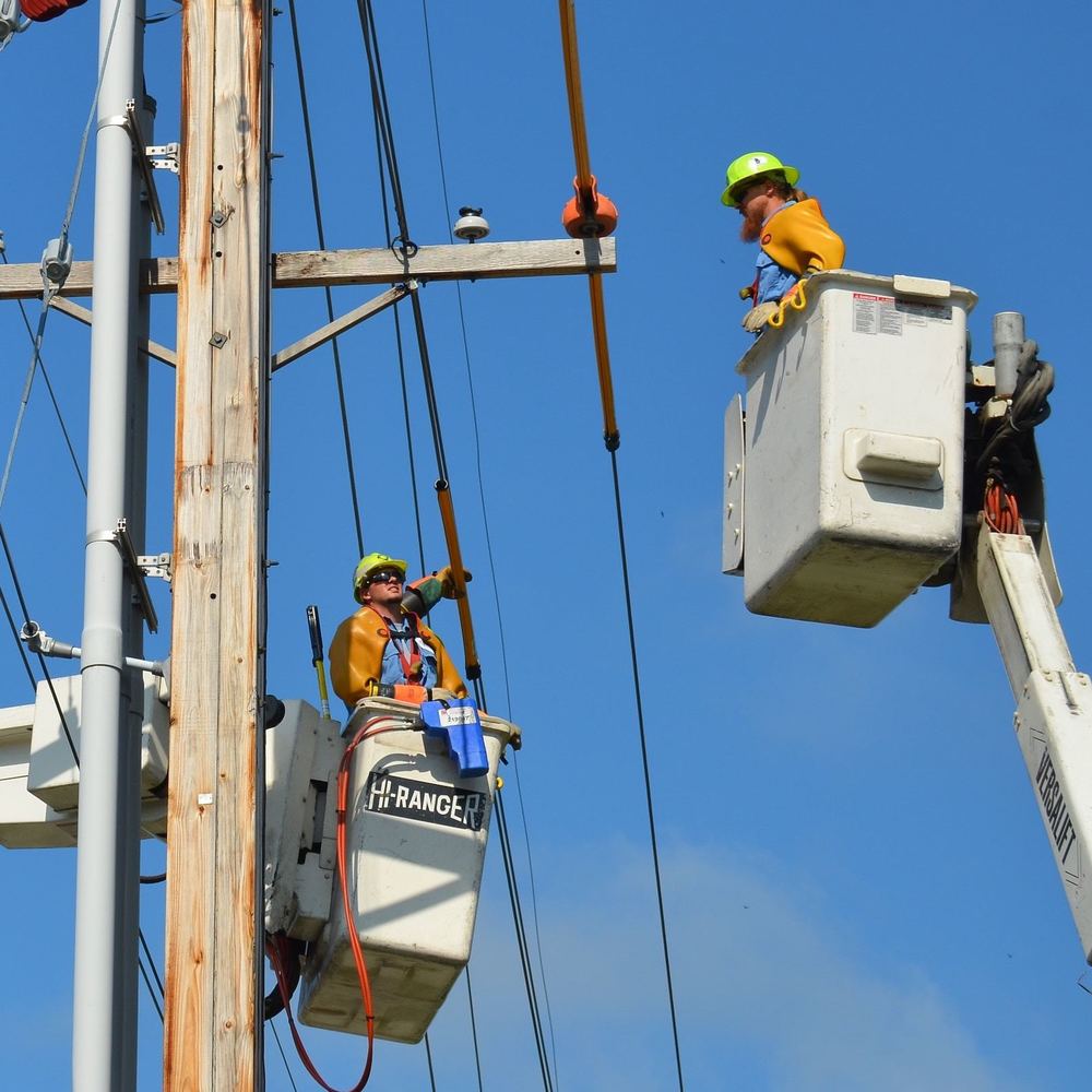Line workers in buckets working on overhead power lines