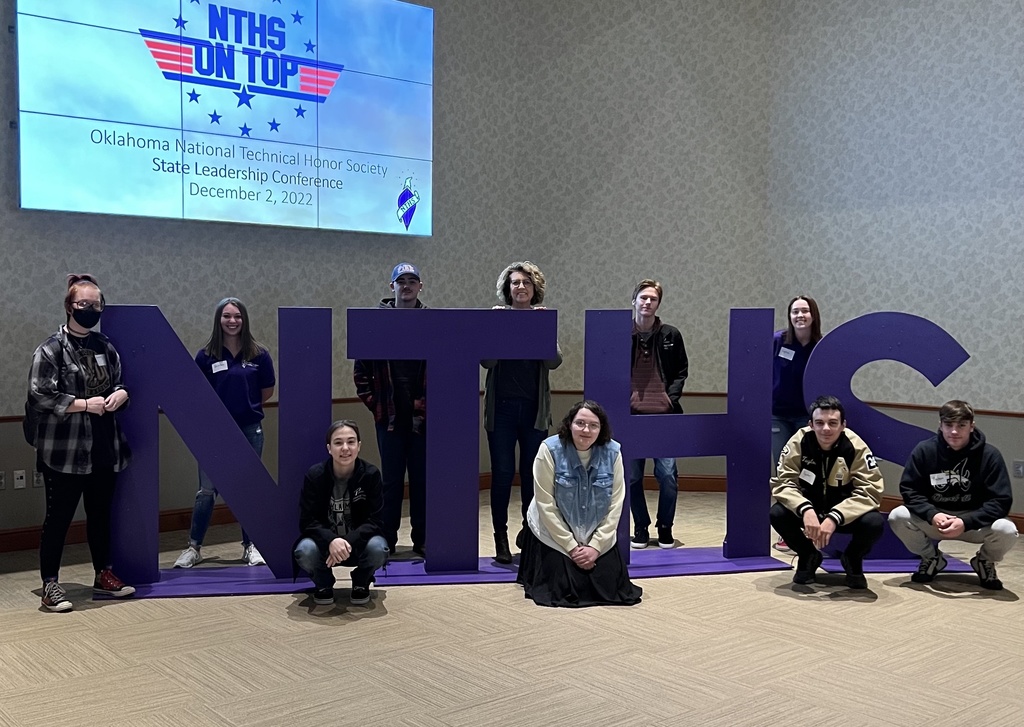 Photo of students arranged around a large NTHS logo