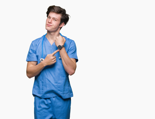 Photo of a nurse with urgent expression pointing at a watch on his wrist