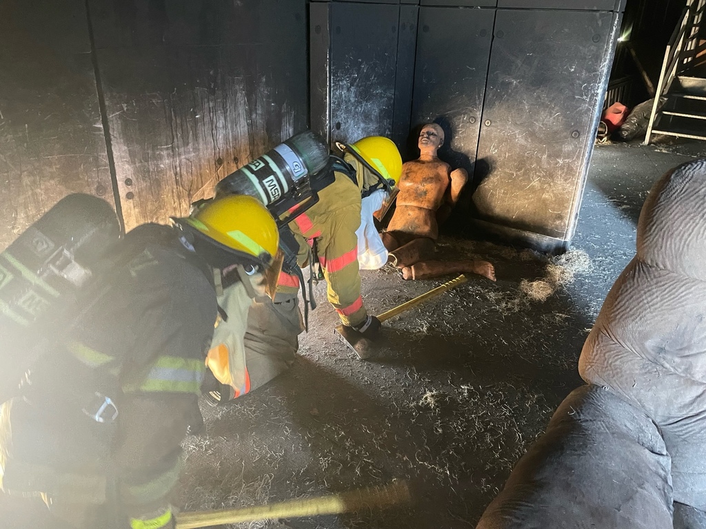 Photo of students in fire gear practicing search and rescue