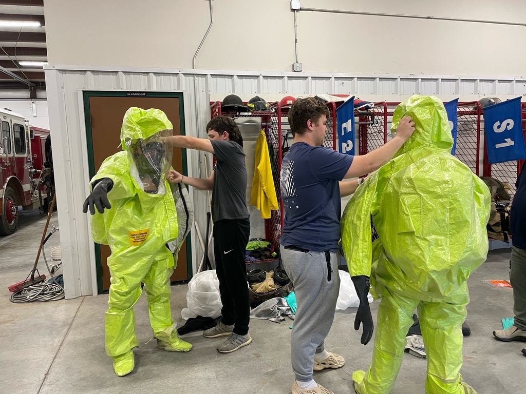 Students putting on PPE equipment for hazardous waste cleanup practice