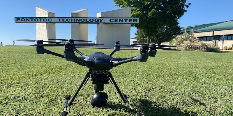 photo of a drone in front of a sign that reads Pontotoc Technology Center