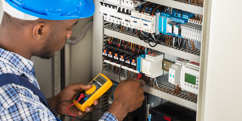 Image of man using a multimeter on a wire bank