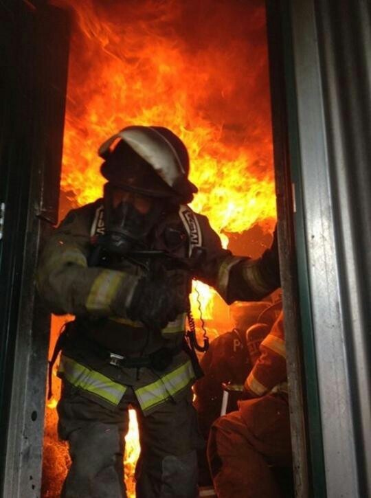 Picture of fire fighter exiting a room full of fire