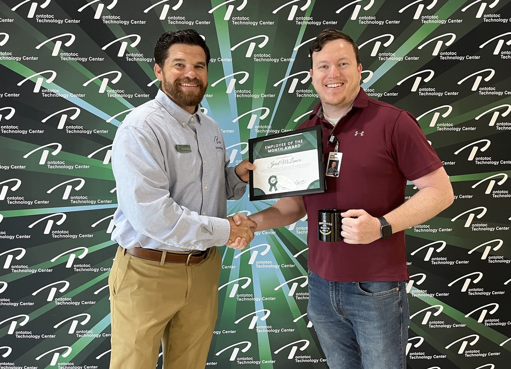 Travis Graham presenting employee of the month certificate to Jared McLemore